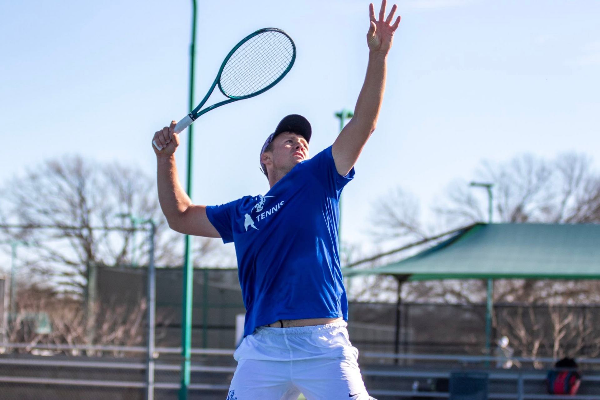 Cem rising into a serve under open sky